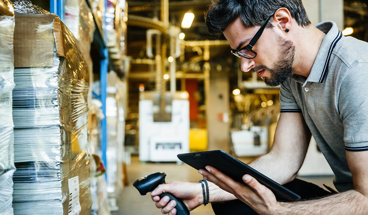 Digitalisierung einer Lagerhalle: Mann scannt mit Tablet Ware